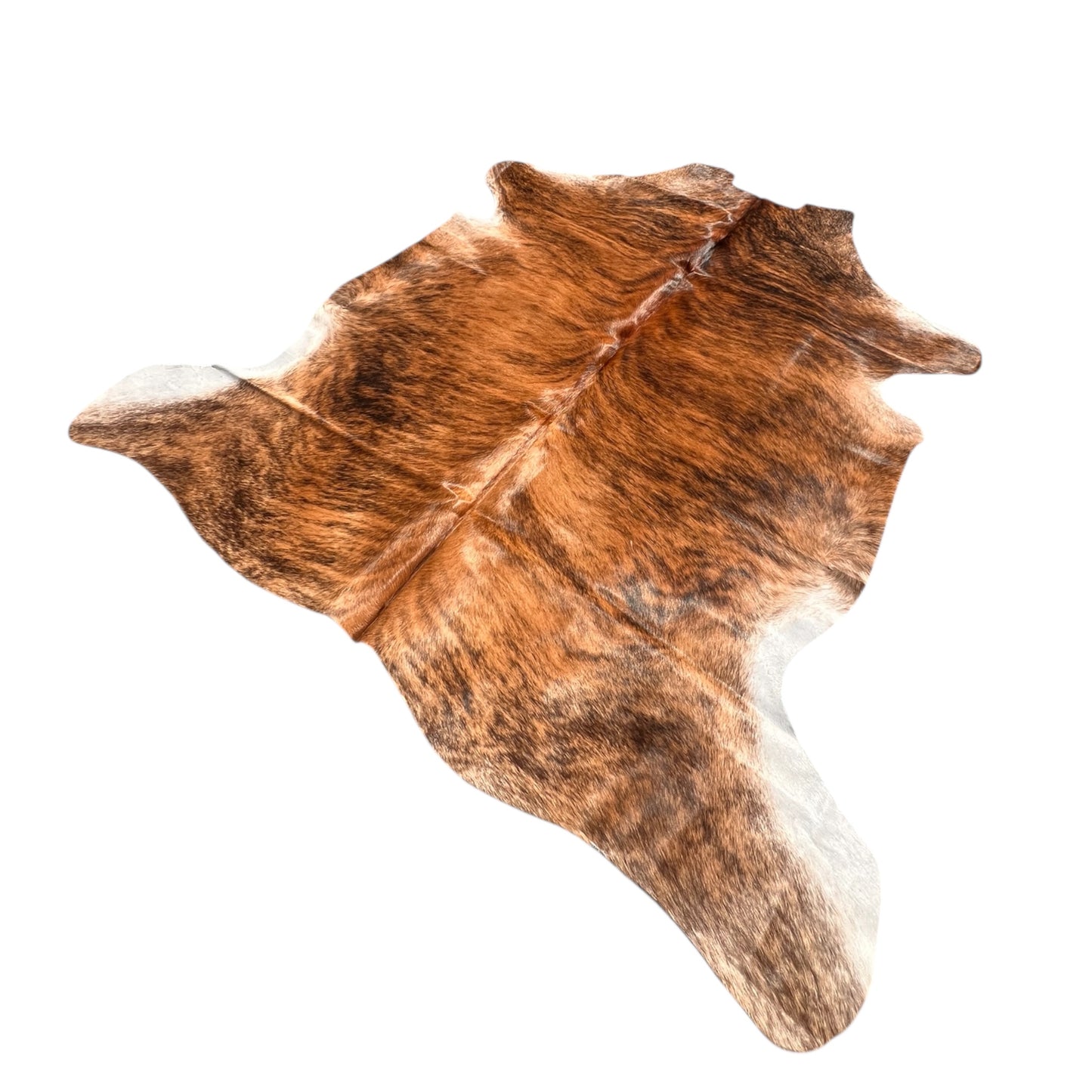 Brindle cowhide rug with rich natural tones of dark brown, black, and caramel, displayed on a wooden floor in a rustic interior. Each hide is one-of-a-kind, showcasing organic patterns and textures that bring warmth, authenticity, and character to any space. Perfect for country homes, modern rustic decor, or as a statement piece in natural interiors.
