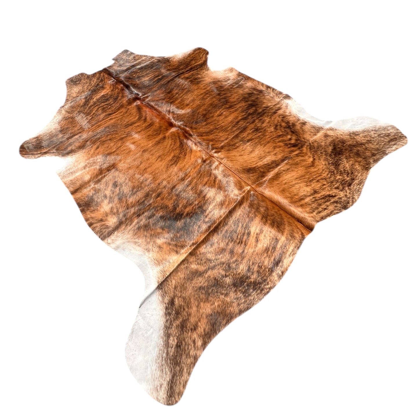 Brindle cowhide rug with rich natural tones of dark brown, black, and caramel, displayed on a wooden floor in a rustic interior. Each hide is one-of-a-kind, showcasing organic patterns and textures that bring warmth, authenticity, and character to any space. Perfect for country homes, modern rustic decor, or as a statement piece in natural interiors.